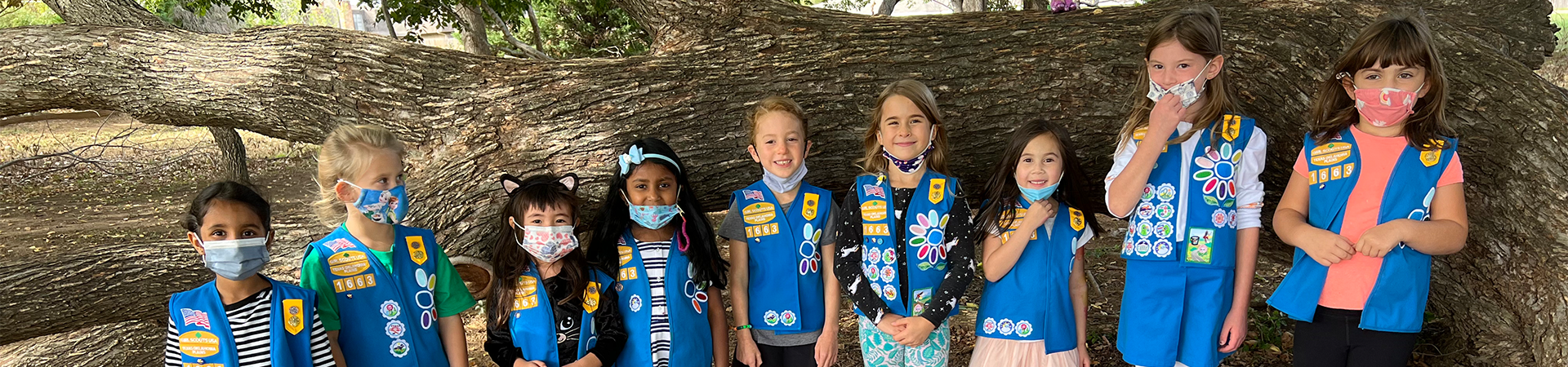  Two daisy Girl Scouts holding lantern in tent wearing trefoil shirt 