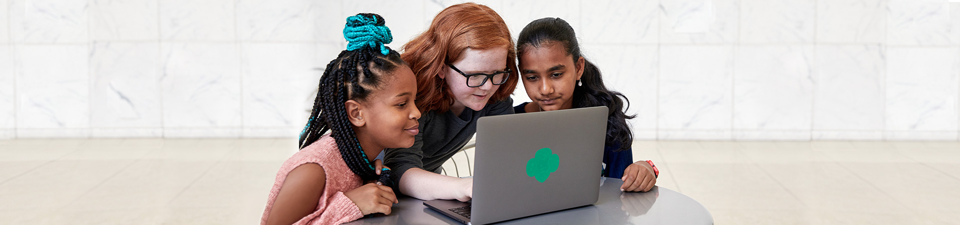  group of girl scouts looking at laptop computer 